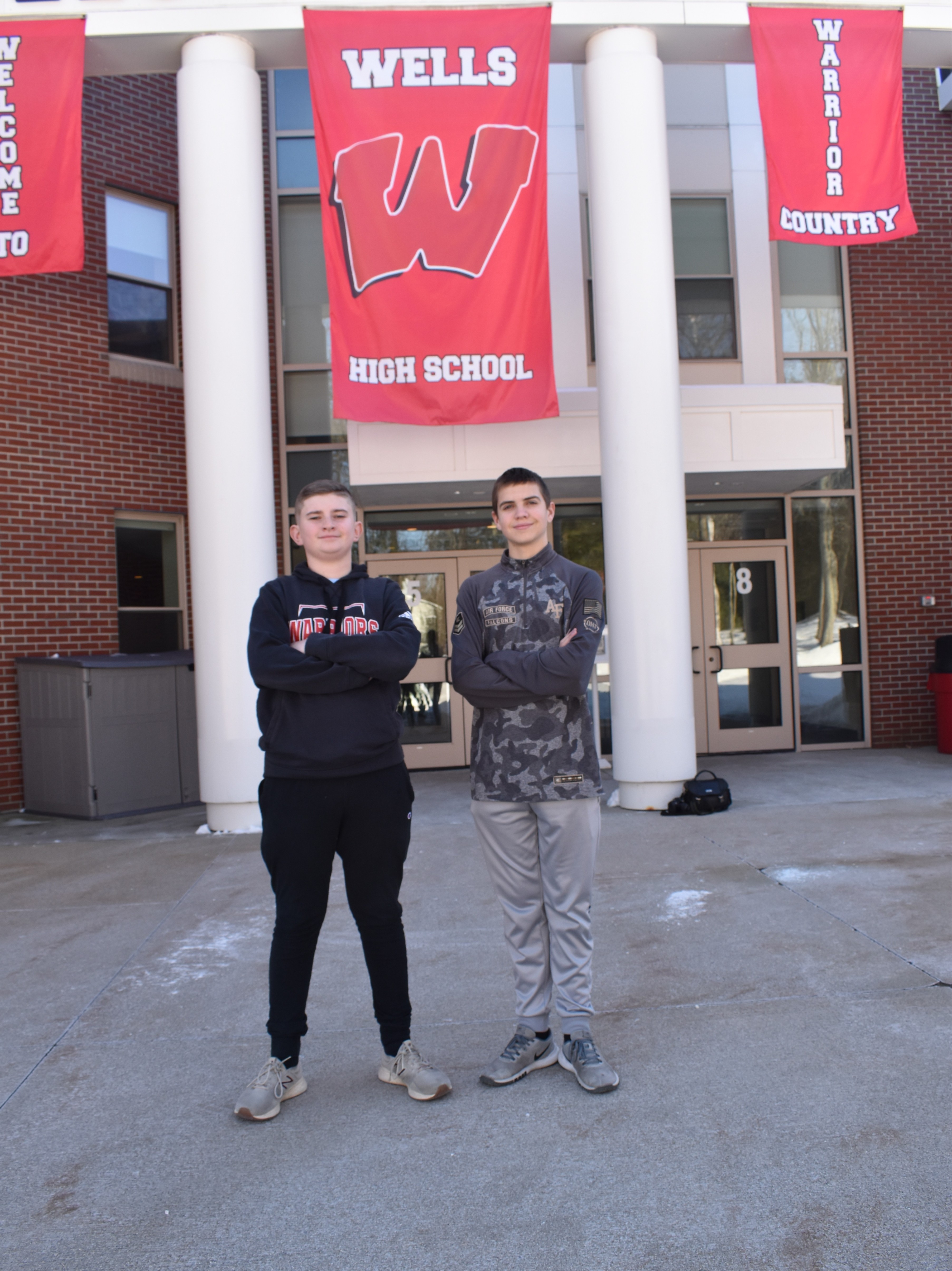 Gavin Dusza and Noah Busick standing in front of the school